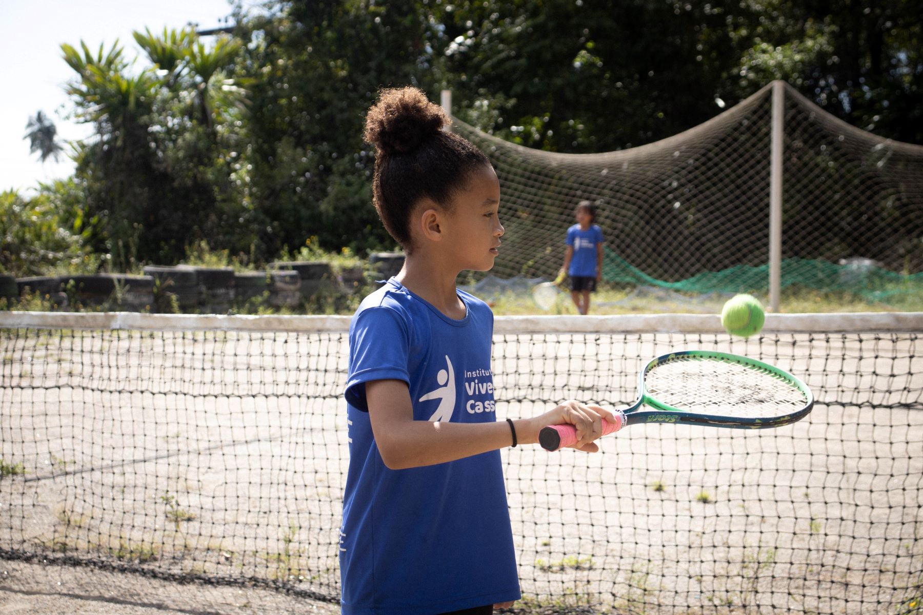 Aluna em atividade de tênis de campo