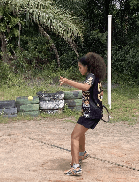 Aluna em treinamento de tênis de campo 